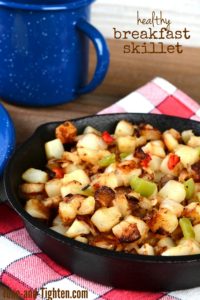 Closeup of a cast iron skillet full of breakfast potatoes. Vertical format with shallow depth of field.